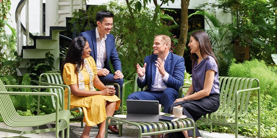 Temasek staff enjoying a lighthearted discussion at Temasek Shophouse’s outdoor garden